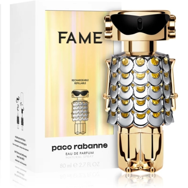 Un flacon de parfum en forme de robot doré avec des lunettes de soleil et un motif d'écailles métalliques sur son torse se trouve à côté d'une boîte étiquetée « Paco Rabanne Fame 80 ml », soulignant ses fonctionnalités rechargeables et rechargées et faisant écho à l'attrait de Paco Rabanne Lady Million. Dakar