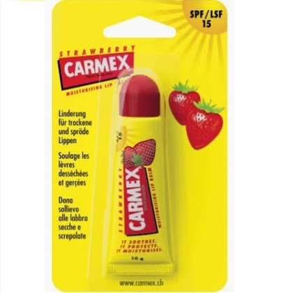 Un emballage jaune de baume à lèvres hydratant FRAISE de Carmex Baume à lèvres avec FPS 15, arborant des graphismes de fraises et un texte multilingue soulignant ses qualités apaisantes et protectrices. Dakar
