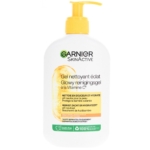 Un flacon blanc de Garnier Crème Nettoyante Éclat à la Vitamine C Peaux Ternes 250 ml avec une pompe jaune. L'étiquette comporte des icônes de vitamine C, de nettoyage doux, d'hydratation, d'absence de cruauté et de végétalisme, ainsi qu'un texte en français et en néerlandais. Dakar