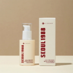 Un flacon couleur crème de KSECRET SÉOUL 1988 Sérum Anti Age, Liposome Rétinien 2% + Ginseng Noir, avec une pompe à côté de sa boîte assortie, toutes deux comportant un texte rouge « SEOUL 1988 » et un logo, sur un fond neutre. Dakar