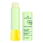 Un tube vert de Stick Lèvres Hydratant Bio Nuxe CITRON DOUX 4 g, sans son bouchon, dévoile le baume onctueux qu'il contient. Un élégant texte souligne son caractère naturel et son délicieux parfum citron meringué. Dakar