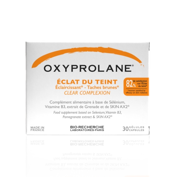 La boîte blanche d'Oxyprolane Éclat du Teint Anti Taches Éclaircissant, avec texte en français et en anglais, contient 30 gélules enrichies en sélénium, vitamine B3 et extrait de grenade. Fabriqué en France par Bio-Recherche Laboratoires-Paris, il complète le collagène Biocyte pour une peau éclatante. Dakar