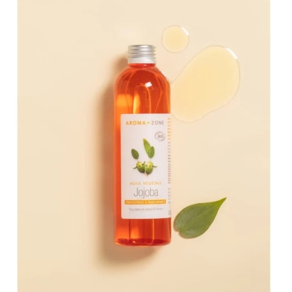 Un flacon d'Huile de Jojoba BIO Aroma Zone 100 ml repose sur une surface couleur crème. D'un orange vif et doté d'un bouchon argenté, ce flacon arbore une étiquette verte à l'effigie d'une plante. À proximité, une feuille verte luxuriante et une touche d'huile essentielle envoûtante évoquent l'essence de l'Huile de Coco Aroma Zone. Dakar