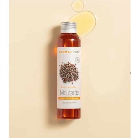 Un flacon d'Huile de Moutarde BIO Aroma Zone de 100 ml repose sur une surface beige, avec de l'huile renversée à proximité. Le flacon est doté d'un bouchon argenté et d'une étiquette ornée de graines de moutarde et de reflets orangés. Dakar