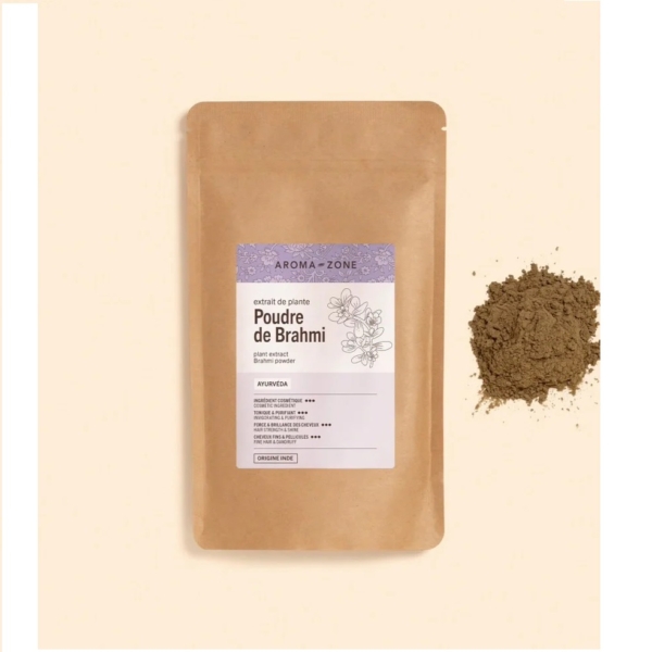Un sachet de Poudre de Brahmi Aroma Zone 250 g (poudre végétale) est posé à côté d'un petit tas de poudre brune sur fond beige clair. Associez-le à l'Huile d'Amla BIO Aroma Zone pour une routine capillaire naturelle optimisée. Dakar