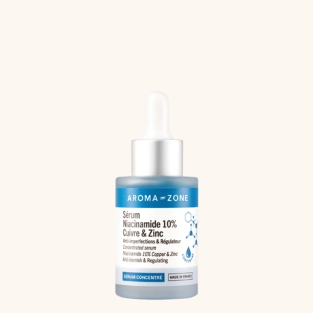 Un flacon de 30 ml du « Sérum concentré Niacinamide 10 % Cuivre et Zinc » d'Aroma Zone, muni d'un bouchon compte-gouttes et d'une étiquette bleu-blanc, est conçu pour réguler la peau et lutter contre les imperfections. Dakar