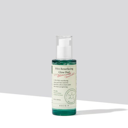 Un flacon de PHA Resurfacing Glow Peel est posé sur une surface plane. Il contient un liquide vert et une pompe blanche. L'étiquette affiche les détails du produit et une ombre douce se projette sur la surface blanche en dessous. Dakar