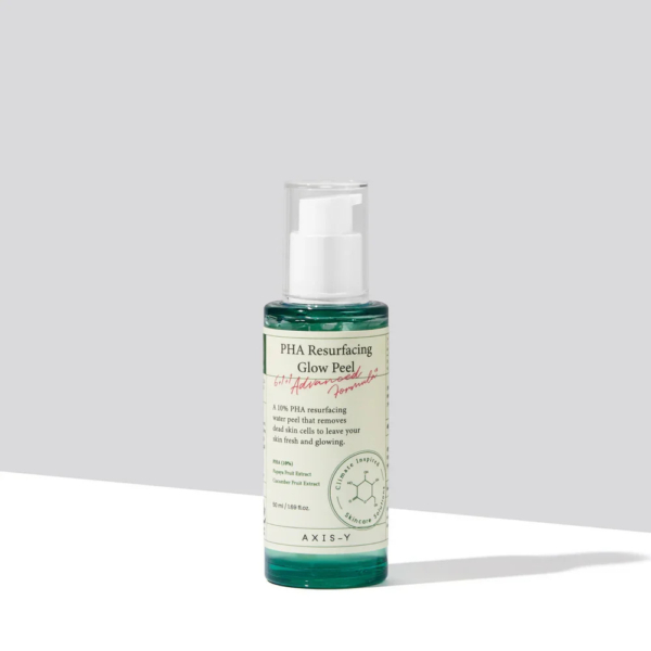 Un flacon de PHA Resurfacing Glow Peel est posé sur une surface plane. Il contient un liquide vert et une pompe blanche. L'étiquette affiche les détails du produit et une ombre douce se projette sur la surface blanche en dessous. Dakar