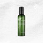 Un flacon vert de lotion tonique à l'aloe vera BHA, avec un bouchon noir et un texte blanc détaillant son contenu. Le fond est d'un gris subtil et texturé, ajoutant une touche minimaliste à la présentation. Dakar