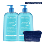 Deux flacons d'un litre de Gel Nettoyant Doux Bioderma Atoderm avec pompe doseuse, étiquetés pour le corps, le visage et les mains. Une pochette Bioderma bleu foncé est incluse à côté des flacons. L'inscription « Trousse Offerte » figure dans le coin supérieur. Dakar