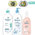 Un coffret de soins pour bébé Biolane : deux biberons avec pompe, un lait corporel et un nettoyant corps et cheveux, ainsi qu'un vaporisateur d'eau de toilette. Deux tétines sont exposées ci-dessus. Le mot « Offert » est inscrit en haut à droite. Dakar