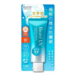 Un tube de crème solaire Bioré UV Aqua Rich SPF 50+ est présenté dans son emballage. L'emballage est bleu avec un texte blanc et orange en caractères japonais. Le tube est bleu clair avec un bouchon blanc. Dakar