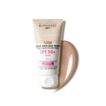Un tube de crème teintée anti-âge Byphasse Daily Use avec SPF 50+ est présenté. La crème est étiquetée « 3 en 1 » et « Bronze ». Une trace de produit est visible à côté du tube, soulignant sa couleur. Dakar