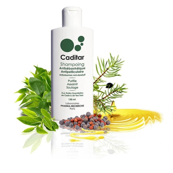 Un flacon de shampoing antiséborrhéique Caditar de 150 ml est orné de feuilles vertes fraîches et de gouttes d'huile parfumées sur un fond blanc immaculé. L'emballage présente un texte en français mettant en avant les bienfaits et les ingrédients, comme l'huile d'arbre à thé nourrissante, similaire à l'hydratant champooing Evashair. Dakar