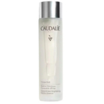 Un flacon translucide d'Essence Glycolique Concentrée Éclat Vinoperfect de Caudalie, avec un bouchon argenté. L'étiquette affiche le nom de la marque, un logo en forme de vigne et les informations produit en français et en anglais. Dakar