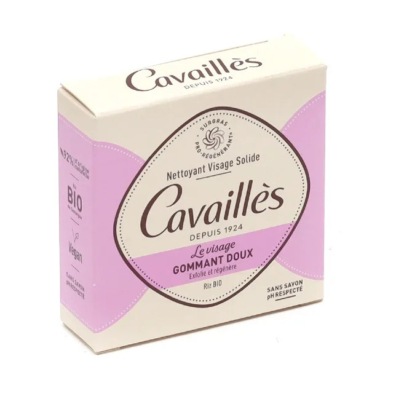 Une boîte rectangulaire de nettoyant visage Cavaillès aux couleurs rose pastel et crème. L'étiquette indique qu'il s'agit d'un nettoyant visage solide exfoliant doux. La boîte mentionne également les certifications « Bio » et « Vegan ». Dakar