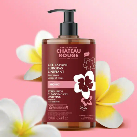 Un flacon de Gel Nettoyant Extra Riche Château Rouge aux fleurs de Monoï sur fond rose. Ce gel pour le visage et le corps, sans savon, contient 95 % d'ingrédients d'origine naturelle et est présenté dans un flacon de 750 ml. Dakar