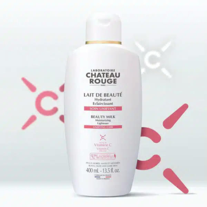 Une bouteille blanche de Lait de Beauté Château Rouge, 400 ml, avec un texte rose soulignant les soins hydratants et éclaircissants. Contient de la vitamine C. Le fond présente des formes roses abstraites et des reflets doux. Dakar