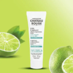 Un tube blanc étiqueté « Laboratoire Château Rouge » se détache sur un fond vert à motifs citron vert. Ce produit est un concentré purifiant anti-imperfections, contenant de l'huile essentielle de citron vert biologique. L'emballage indique qu'il est destiné aux peaux à imperfections. Dakar