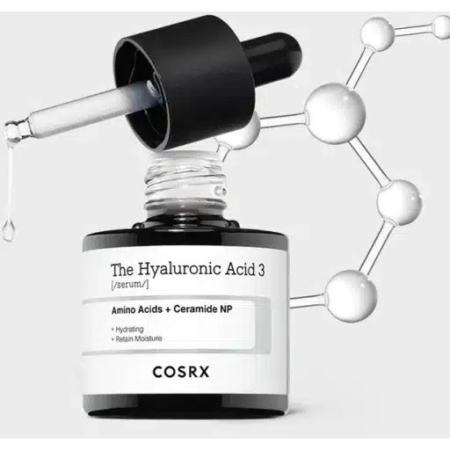Gros plan sur un flacon de sérum COSRX Hyaluronic Acid 3 avec un compte-gouttes déversant une goutte. L'étiquette indique « Acides aminés + NP de céramide » pour l'hydratation et la rétention d'eau. Une structure moléculaire est illustrée en arrière-plan. Dakar