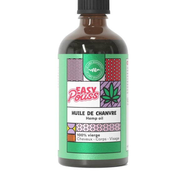 Un flacon d'huile de chanvre Easy Pouss avec une étiquette verte ornée de motifs géométriques colorés et d'un motif de feuille. L'étiquette indique « 100 % vierge » et « Cheveux - Corps - Visage », indiquant qu'elle est destinée aux cheveux, au corps et au visage. Dakar