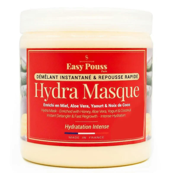 Gros plan sur un flacon de masque Hydra Easy Pouss. L'étiquette met en avant des ingrédients comme le miel, l'aloe vera, le yaourt et la noix de coco. Elle met l'accent sur le démêlage, la repousse rapide et l'hydratation intense. L'emballage est orné de touches de rouge et porte la mention « Fabriqué en France ». Dakar