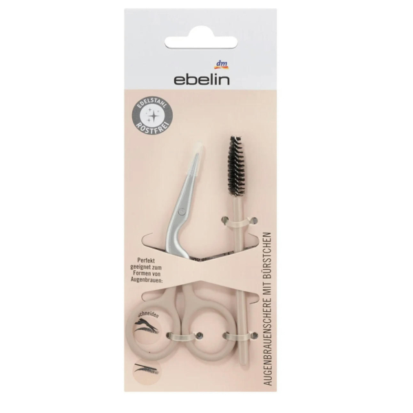 Emballage d'un kit de soins des sourcils comprenant une paire de ciseaux à lames courbes et une brosse à brosse. Le kit porte l'inscription « edlestahl rostfrei », indiquant l'acier inoxydable, et porte les logos « ebelin » et « dm ». Dakar