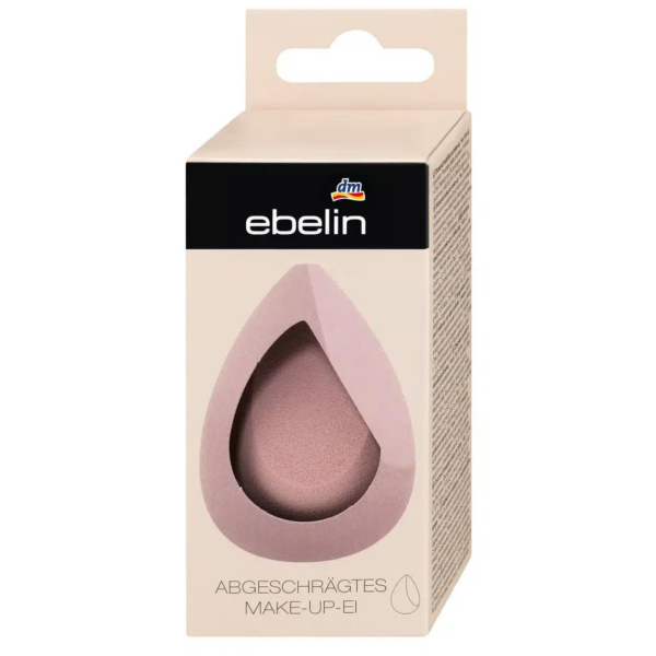 Une éponge à maquillage inclinée en forme de larme est présentée dans son emballage beige. La boîte est dotée d'une découpe laissant apparaître l'éponge à l'intérieur. L'emballage arbore le logo de la marque « ebelin ». Dakar
