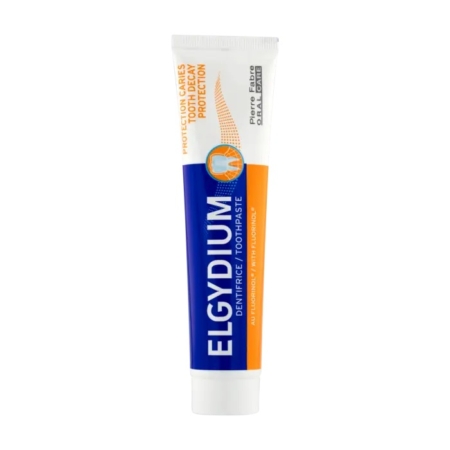 Tube de dentifrice Elgydium, aux couleurs bleu et orange. Le texte « Protection contre la carie » met l'accent sur la protection contre la carie dentaire, avec l'inscription « Protection contre la carie dentaire » en orange sur fond blanc. Dakar