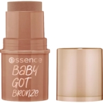 Un stick de maquillage bronze sans bouchon, avec l'inscription « essence BABY GOT bronze » sur le tube. Ce produit est d'une teinte bronze irisée. Dakar
