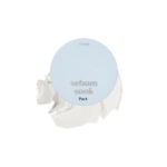 Un compact bleu clair portant le texte « sebum soak Pact » sur le dessus, avec une substance crémeuse beige visible derrière, probablement de la poudre pour le visage ou du maquillage à la texture lisse. Dakar