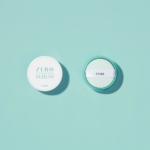 Vue de dessus du poudrier Zero Sebum d'Etude, ouvert pour révéler une houppette blanche. Le poudrier et son couvercle, ronds et turquoise clair, reposent sur un fond turquoise assorti. Dakar
