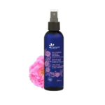 Un vaporisateur bleu foncé, étiqueté « Eau Florale de Rose de Damas », aux motifs floraux roses, trône à côté d'une rose rose en fleurs. Ce flacon, produit par Fleurance Nature, contient 200 ml d'Eau Florale de Rose de Damas. Dakar