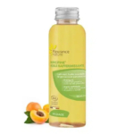 Un flacon transparent d'huile raffermissante Mincifine de Fleurance Nature, étiqueté en français, contenant un liquide jaune. L'étiquette mentionne du café vert et des huiles essentielles. Deux abricots sont présents à côté du flacon. Ce produit est destiné au massage. Dakar