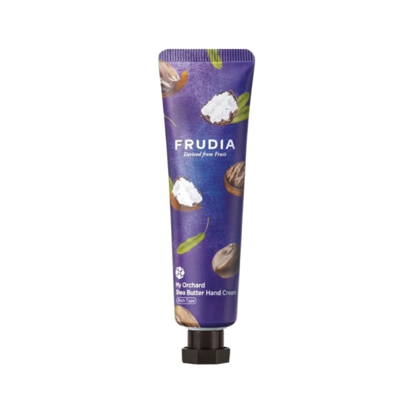 Tube de crème pour les mains au beurre de karité Frudia My Orchard sur fond blanc. Le tube est violet foncé avec des motifs de noix de karité et de feuilles vertes. Le nom de la marque « Frudia » est bien visible. Dakar