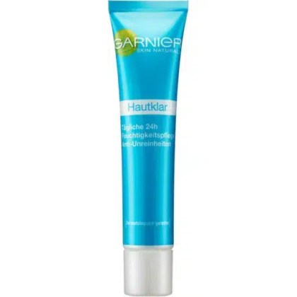 Un tube bleu et blanc de crème hydratante Garnier Skin Naturals Hautklar. Le texte sur le tube est en allemand, indiquant qu'il offre une hydratation 24 heures et un soin anti-imperfections. L'emballage est élégant et doté d'un bouchon argenté. Dakar