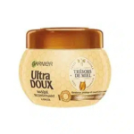 Un pot de masque capillaire Garnier Ultra Doux au motif nid d'abeille. L'étiquette porte l'inscription « Trésors de Miel » et présente des images de miel et de cire d'abeille. Le couvercle est brun doré. Dakar