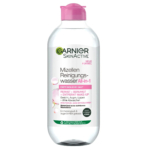Un flacon en plastique transparent d'Eau Micellaire Nettoyante Garnier SkinActive. L'étiquette, en allemand, indique qu'il s'agit d'un nettoyant tout-en-un pour peaux sensibles, sans parfum, adapté au visage, aux yeux et aux lèvres. Le bouchon est rose. Dakar