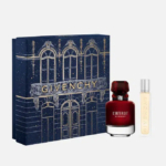 Un coffret cadeau luxueux comprenant un grand flacon de parfum L'Interdit de Givenchy et un petit vaporisateur de voyage, placé devant une élégante boîte au design artistique bleu foncé avec des accents dorés. Dakar
