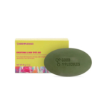 Un pain de savon ovale vert, gravé « Good Molecules », est placé devant une boîte jaune. Cette dernière est ornée d'un motif abstrait coloré et porte l'inscription « Brightening & Dark Spots Bar » (Barre éclaircissante et anti-taches brunes) ainsi que les informations produit. Dakar