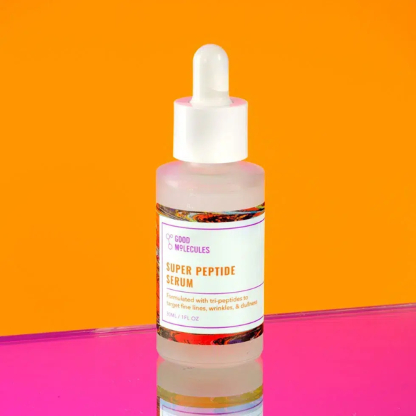 Un flacon de sérum Super Peptide avec un bouchon compte-gouttes, sur fond orange vif. Le flacon est orné d'une étiquette blanche avec texte, dont le reflet est visible sur une surface rose en dessous. Dakar
