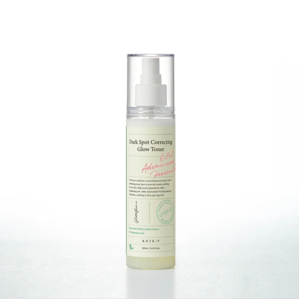 Un flacon de lotion tonique anti-taches AXIS-Y avec pompe. L'étiquette est verte et rouge, et le flacon est transparent, laissant apparaître le liquide à l'intérieur. Le fond est blanc uni. Dakar