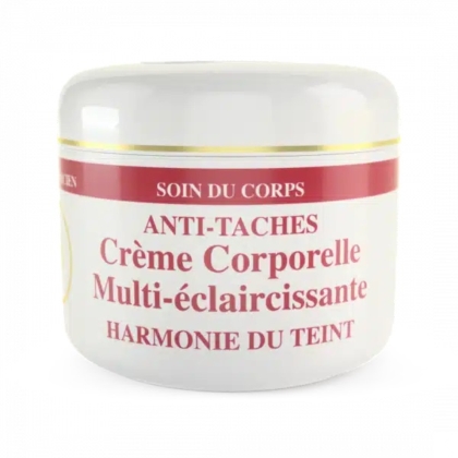 Un pot blanc de crème de soin portant l'inscription « Anti-Taches Crème Corporelle Multi-éclaircissante Harmonie du Teint » avec une bande rouge et or sur le dessus. Le texte est en français, indiquant qu'il s'agit d'une crème pour le corps harmonisant le teint. Dakar