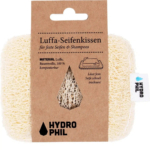 Un coussin de savon en luffa avec une étiquette en carton. L'étiquette indique en allemand que le produit est fabriqué à partir de luffa et de coton 100 % compostables. Le logo HYDROPHIL est visible sur l'étiquette et sur le coussin. Dakar