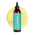 Un flacon d'huile miracle étiqueté « N Haircare », avec une étiquette turquoise et un bouchon noir, est posé devant une goutte d'huile jaune clair. L'étiquette affirme que l'huile fortifie et nourrit. Le flacon contient 200 ml. Dakar