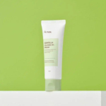Un tube de gel-crème apaisant à la centella d'iUNIK se détache sur un fond vert vif. Le tube blanc porte une étiquette verte et un bouchon gris. L'étiquette mentionne un effet éclaircissant et un effet antirides. Dakar