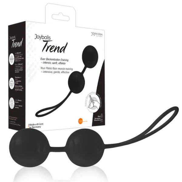 Image de l'appareil d'entraînement du plancher pelvien Joyballs Trend noir, composé de deux sphères reliées par une poignée en boucle. Le produit est présenté à côté de son emballage, qui met en avant ses avantages, tels qu'un entraînement musculaire intensif et doux, fabriqué en Allemagne. Dakar