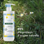 Un flacon de lotion hydratante Klorane Bébé au calendula est posé sur une pelouse parsemée de petites fleurs blanches. L'inscription « 96 % d'ingrédients d'origine naturelle » est inscrite sur le flacon, muni d'une pompe doseuse et d'un design inspiré de la nature. Dakar