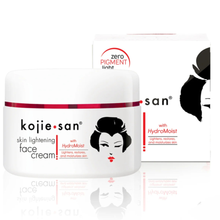 Un flacon blanc de crème éclaircissante pour le visage Kojie San est présenté devant sa boîte. Les deux produits arborent un visage de femme stylisé en noir et rouge. Le texte souligne « avec HydroMoist » et « éclaircissement sans pigment ». Dakar
