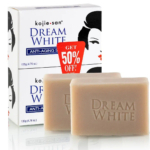 Voici l'emballage du savon anti-âge Kojie San Dream White. La boîte, ornée d'une silhouette de visage, se trouve derrière deux savons beiges estampillés « Dream White ». Une étiquette rouge sur la boîte indique : « 50 % de réduction ! ». Dakar